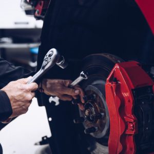 Car mechanic repairing car brakes in car service